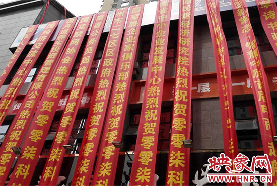 路邊一棟樓上懸掛著二三十條紅色條幅，全部是祝賀一家公司開業(yè)的。