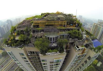 　　昨日，身穿橘黃色馬甲的工作人員在人濟(jì)山莊樓頂拆除違章建筑。新京報(bào)記者 吳江 攝