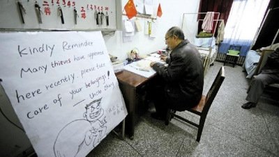 張大爺在門衛(wèi)室里工作，旁邊是紅爆網(wǎng)絡(luò)的溫馨提示牌記者