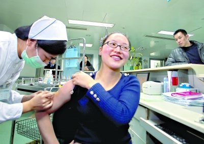 昨日，向雪敏在同濟醫(yī)院血液科病房打動員劑，丈夫陳武右在身后注視著妻子 記者傅克強