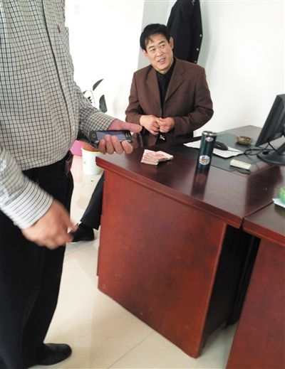 10月29日，獻縣國稅局稽查局辦公室內(nèi)，一名企業(yè)主交了兩萬元現(xiàn)金在桌上。新京報記者 孟祥超 攝