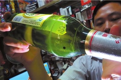 這瓶未開(kāi)封的燕京啤酒內(nèi)有一顆黑色懸浮物。京華時(shí)報(bào)記者 徐曉帆 攝