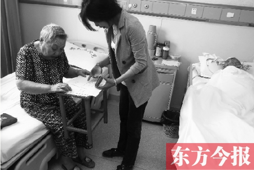 昨日，鄭大五附院二號(hào)樓住院部，馬老太寫下委托書，并簽字摁指印委托女兒代理為昏迷老伴解鎖取錢