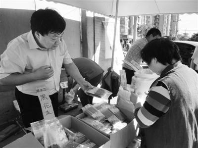 昨日，河南企業(yè)家劉春喜在京“練攤”，為顧客挑選綠豆。新京報(bào)記者 張玉學(xué) 攝