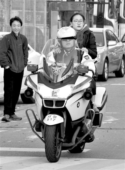 7日，首爾，警察將一名考生送抵考場。新華社發(fā)