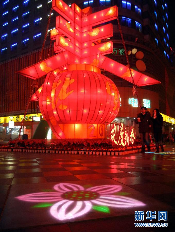 　1月30日晚，市民從蘇州市石路銀河廣場上大型“春”字彩燈景觀旁經(jīng)過。