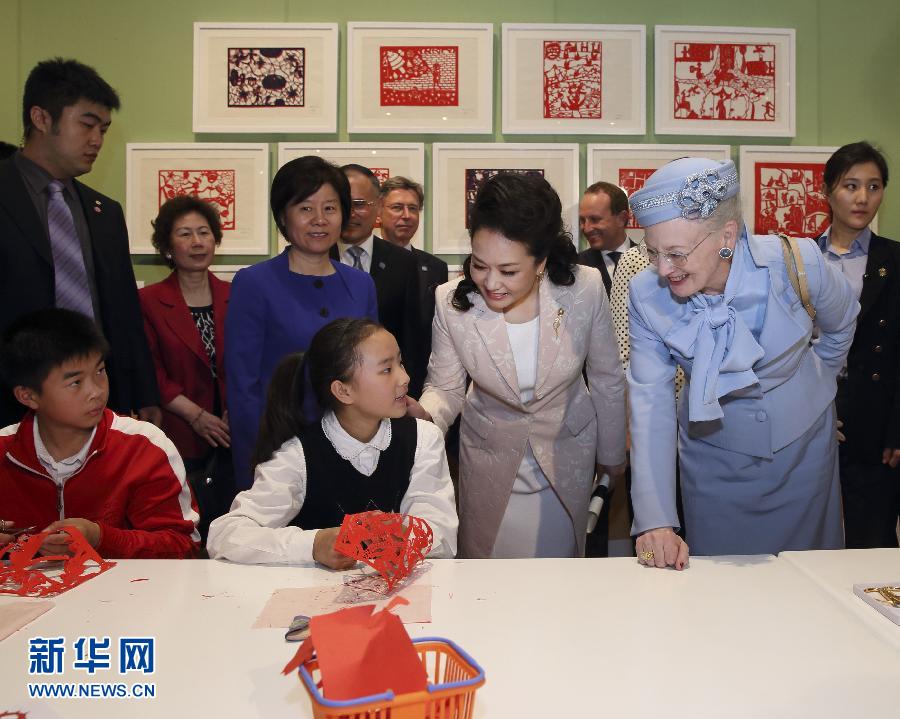 這是彭麗媛和瑪格麗特二世與根據(jù)安徒生童話中人物和情節(jié)制作剪紙的孩子交談。