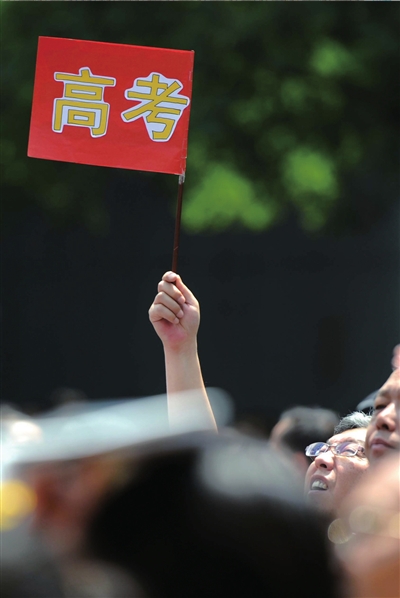6月7日，在東直門考點(diǎn)外，一名家長手舉高考的小旗子迎接孩子。資料圖片本報記者王苡萱攝