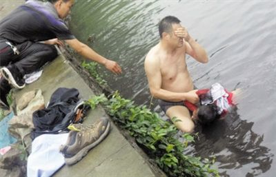 網(wǎng)友貼出民警張光聰一出河水就睜不開眼，用手抹去臉上臟水的照片。