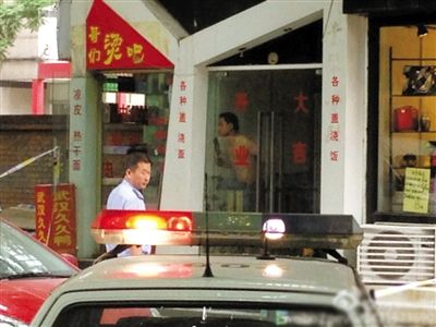 闖入面館的持刀男子與趕來的民警隔著玻璃門對峙，后店內(nèi)一名女童被其劫持。網(wǎng)友供圖