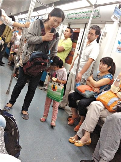 6月27日，舒馨帶一女孩在地鐵十號(hào)線行乞。她因被疑帶多個(gè)不同小孩乞討被警方搜尋。新京報(bào)記者 申志民 攝