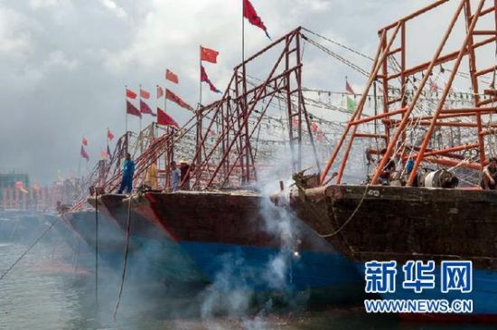 2013年8月1日 南海開漁日 臨高迎新港 8月1日，海南省臨高縣漁民在船上鳴放鞭炮慶祝武蓮港開港。
