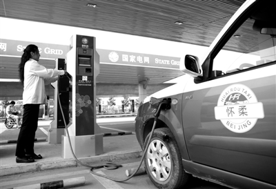 9月11日，懷柔區(qū)，電動(dòng)出租車司機(jī)正在為車輛充電。