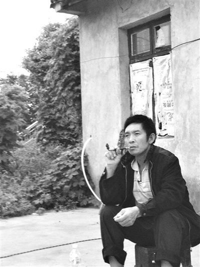 9月12日，陳文才在自己的出租屋旁抽煙。新京報(bào)記者 朱柳笛 攝