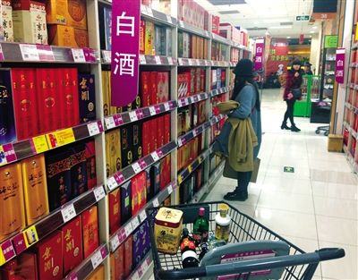 顧客在商場的高檔白酒貨架前駐足挑選。春節(jié)臨近，受“禁令”影響，以高檔白酒為代表的節(jié)日禮品市場面臨考驗(yàn)。記者 王遠(yuǎn)征 攝