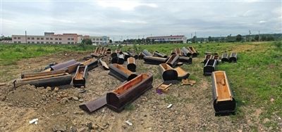 40多副棺木被砸壞后，扔在荒地上。