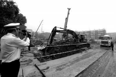 學(xué)院南路一科研樓項目有3臺挖掘機(jī)違規(guī)進(jìn)行土方作業(yè)，被城管隊員當(dāng)場責(zé)令停工。京華時報記者歐陽曉菲攝