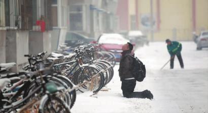 小伙子跪在樓前，一直抬頭看著樓上。 孫立國/攝