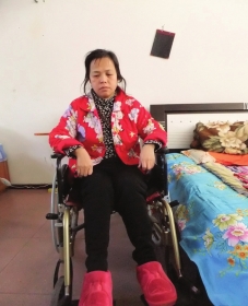 陳慶霞坐在輪椅上。她現(xiàn)在下身癱瘓，疾病纏身，生活不能自理。
