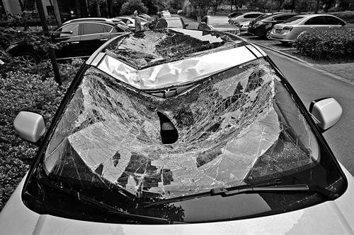 越野車車蓋以及前擋風(fēng)玻璃被砸得凹陷進去。見習(xí)記者姚卡/攝