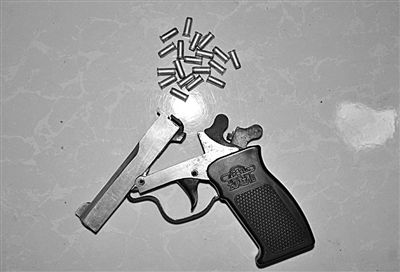 警方從搶劫嫌疑人處起獲的贓款和發(fā)令槍、子彈。警方供圖