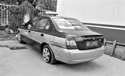 昨日，被撞爆胎的“克隆”出租車，停在朝陽(yáng)交通支隊(duì)奧運(yùn)村大隊(duì)院內(nèi)。新京報(bào)記者 黃月 攝