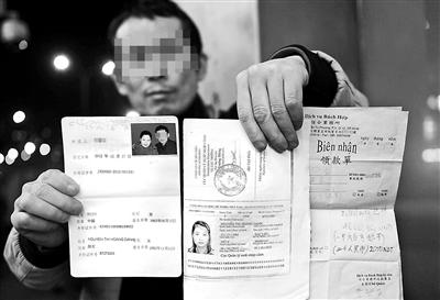 賀先生向記者出示他與越南妻子的結(jié)婚證、新娘護照和部分相關(guān)交費單據(jù) 攝影/本報記者　袁藝