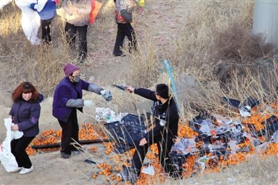 1月4日，連霍高速蘭州市榆中縣和平鎮(zhèn)段，一名警察舉著槍驅(qū)散哄搶橘子的村民。圖/CFP
