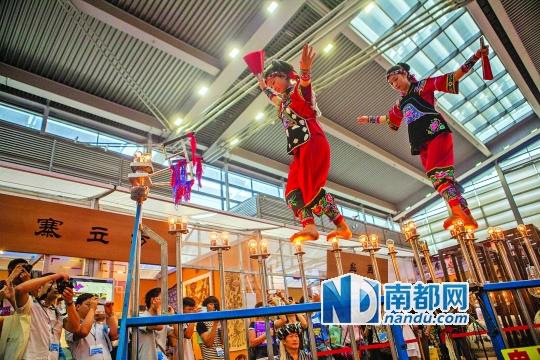 2號(hào)展館，苗族姑娘表演踩燈泡絕技《電光玫瑰》，赤腳踩上40瓦的燈泡并做出高難度動(dòng)作。 南都記者 霍健斌 攝
