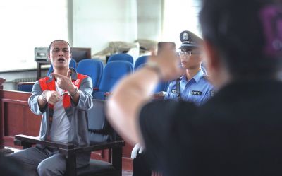 張志國(guó)在法庭上用手語(yǔ)回答提問。記者 蒲東峰攝