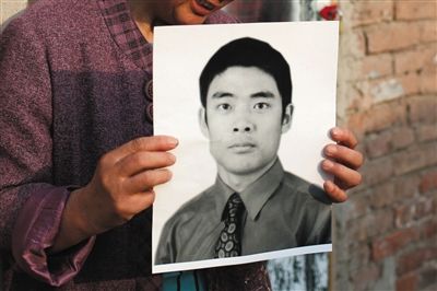 5月19日，朝陽(yáng)北路，母親捧著張東文的遺像。新京報(bào)記者 侯少卿 攝