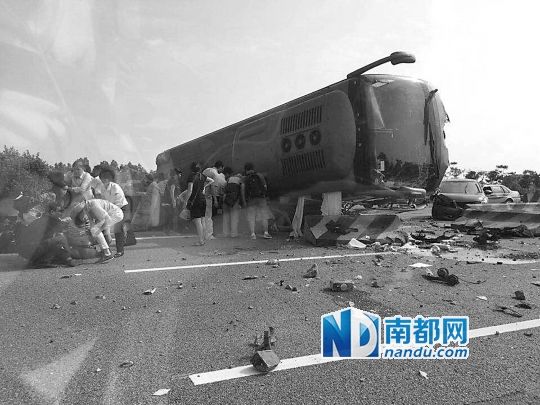 現(xiàn)場(chǎng)大客車側(cè)翻，玻璃碎落一地，車身卡在路邊水泥護(hù)欄上。 目擊者供圖