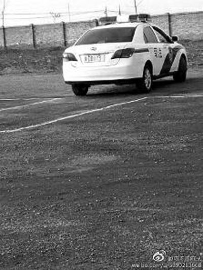 一輛車牌號 為“ 陜DD173”的制式警車停在一個劃著白線的場地上，車身標有“司法”字樣