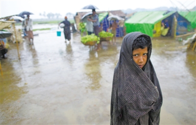 5月14日，緬甸若開(kāi)邦實(shí)兌難民營(yíng)，羅興亞族難民在雨中行走。熱帶風(fēng)暴“馬哈森”即將登陸緬甸，這里的難民開(kāi)始乘船撤離。