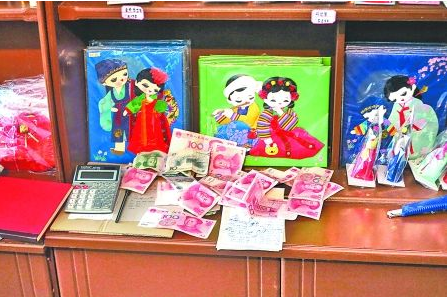 　　2012年6月21日，在朝鮮羅先特別市的一家商店里，柜臺上散落著一些人民幣。在朝鮮，人民幣比本國