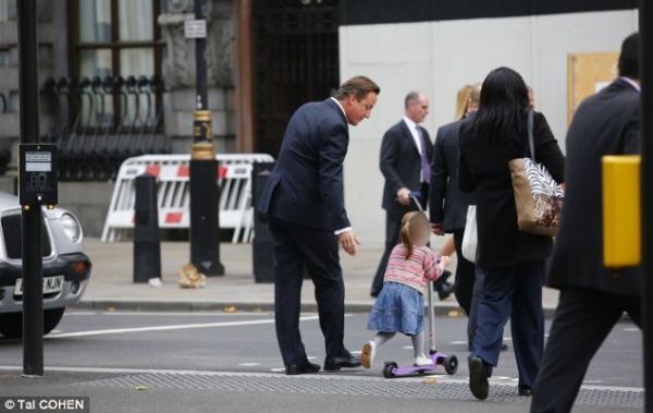 英國(guó)首相卡梅倫步行送女兒上幼兒園。