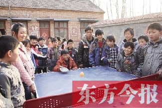 坐著輪椅的小宗成和同學(xué)們一塊打乒乓球，這是他感到最快樂的事