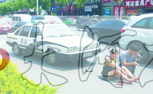 事故發(fā)生后，警車司機(jī)（右）下車查看傷者并撥打120，倆“領(lǐng)導(dǎo)”穩(wěn)坐車內(nèi)引發(fā)圍觀者不滿。