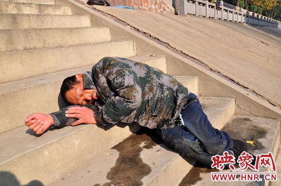 這名男子的衣服以及褲子全濕透了，水從衣褲里流出來，嘴里散發(fā)著濃烈的酒氣。
