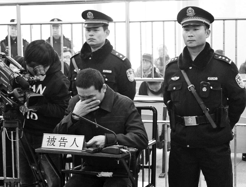 庭審中,29歲的李軍低著頭。