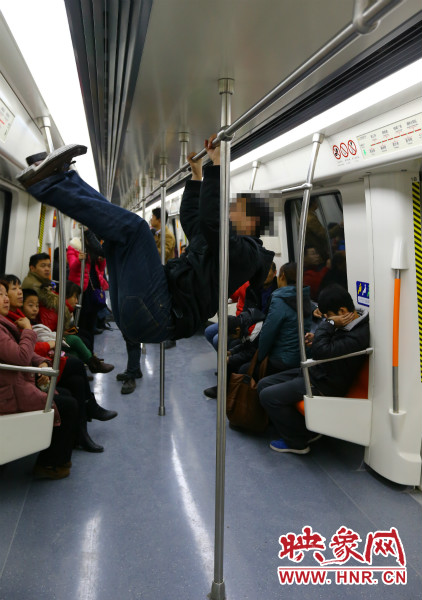 地鐵試乘日，一男子在車(chē)廂內(nèi)攀爬扶手自?shī)首詷?lè)