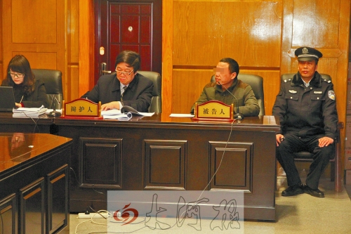 庭審現(xiàn)場，被告人坐在律師身旁為自己辯護(hù)。