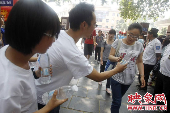 志愿者為剛剛考試完的考生送上1瓶冰凍的冰露·純悅，消暑解渴為考生加油