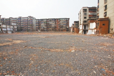 為降塵，旮旯王村拆遷后裸露的地面上鋪了一層石子。