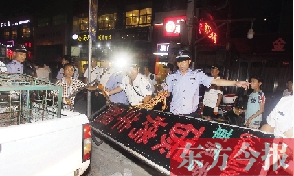 7月8日晚，鄭州市商城路一家占道經(jīng)營(yíng)的攤販招牌被執(zhí)法隊(duì)員“登記保存”