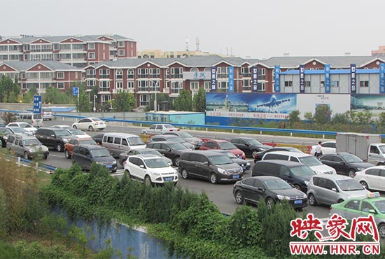 記者看到鄭州機場收費站口車輛排隊，與此形成鮮明對比的是，路的對面（另一半幅）卻車輛較少，通行順暢。