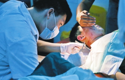 孩子身上有7道傷痕，其中兩道需要縫合，其他的均為擦傷，醫(yī)生正對(duì)他施治。