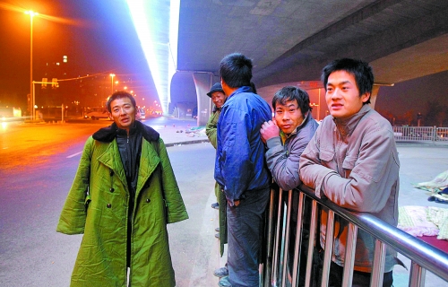 冬夜里，農(nóng)民工在橋下等著干活兒。