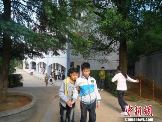 4年來，13歲的余興泉（左一）每天都攙扶著腿腳不便的同學(xué)左臣進(jìn)出教室、食堂和廁所。 李俊杰 攝