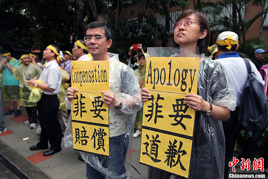 　圖為當(dāng)天下午，當(dāng)臺(tái)灣數(shù)百漁民在馬尼拉經(jīng)濟(jì)文化辦事處前抗議時(shí)，有兩名年輕人手持標(biāo)語(yǔ)，在路邊聲援。中新